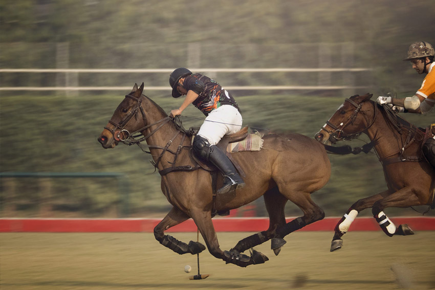 person riding a horse and playing Polo