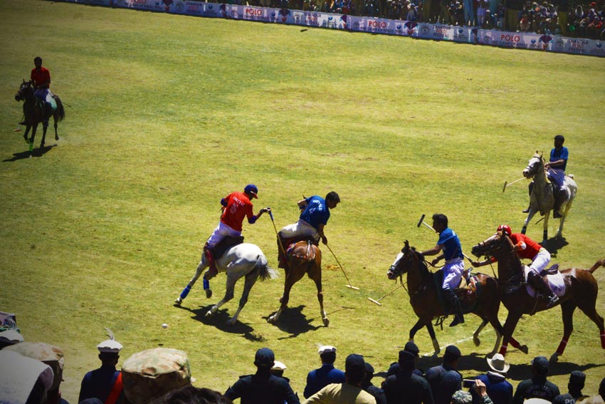 players riding horses and playing polo
